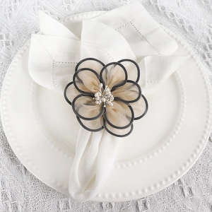 Elegant beige double-layer mesh flower napkin ring with white pearl center on white plate