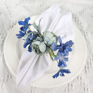 Blue rose and green leaves napkin ring on white porcelain plate for dining table decor