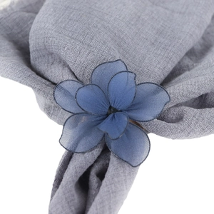 Navy blue mesh flower napkin ring with metal plating on grey fabric background