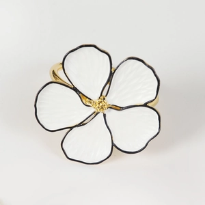 Detailed close-up of a gold-plated flower napkin ring with five white petals and golden stamen