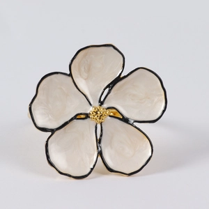 Detail of five-petal flower napkin ring with cream enamel and gold stamen accents