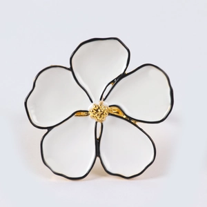 Detail of five-petal flower napkin ring with white enamel finish and gold center