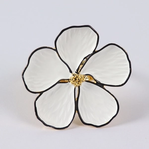 Detail of five-petal white enamel flower napkin ring with gold stamens and metal band
