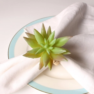 Close-up of artificial succulent plant napkin ring on a white plate with blue stripes