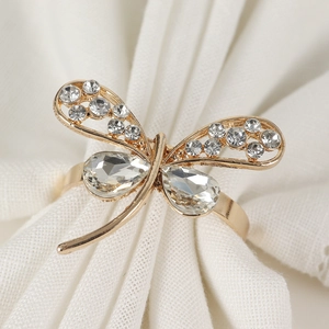 Close-up of golden dragonfly napkin ring with sparkling rhinestones and hollow wings