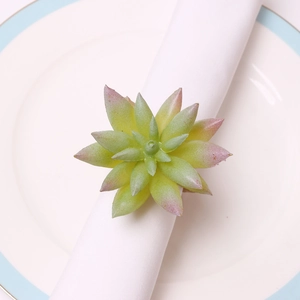 Artificial succulent napkin ring in green and pink gradient on a white plate
