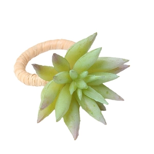 Green faux succulent napkin ring with rustic hand-woven grass base on white background