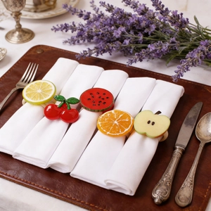 Détail de cinq ronds de serviette en forme de fruits variés comme le citron et l'orange