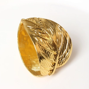 Macro view of gold leaf napkin ring with detailed vein texture on polished metal finish
