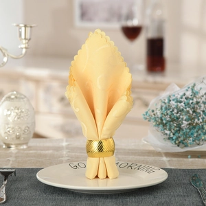 Golden wavy striped napkin ring with spiral texture on an elegant table setting