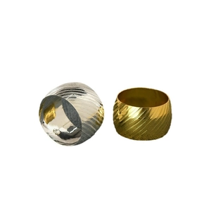 Polished wavy stripe metal napkin rings in gold and silver finish set on white background