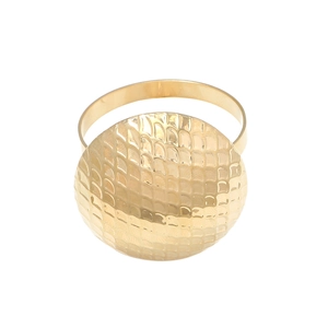 Rond de serviette doré avec texture martelée en écailles de poisson sur plateau circulaire