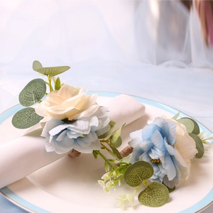 Handmade bicolor floral napkin rings with silk roses and greenery on white ceramic plates