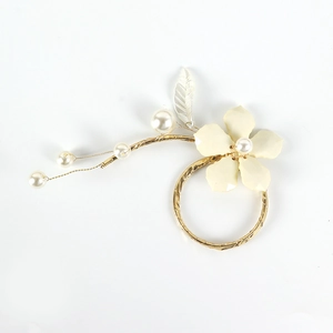White enamel flower napkin ring with gold twisted base and decorative pearl accents