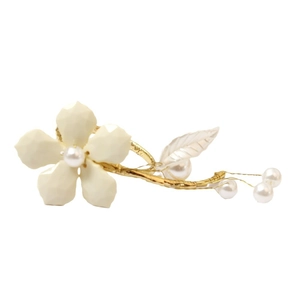 White enamel flower napkin ring with central pearl and gold wire frame for table decor