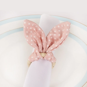 Pink polka dot rabbit ear napkin ring on white plate for elegant table decoration