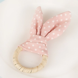 Close-up of pink polka dot bunny ear napkin ring with a natural wooden teething loop