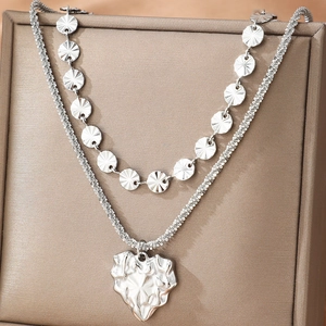 Double-layered silver necklace featuring a textured heart pendant on a premium jewelry box