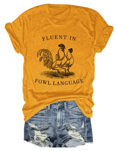 Close-up of yellow cotton t-shirt with rooster graphic and denim shorts flat lay