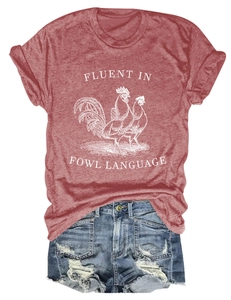 Close-up of brick red t-shirt with chicken print and distressed denim shorts with fringe