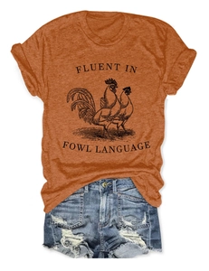 Flat lay of burnt orange rooster t-shirt and distressed denim shorts casual outfit