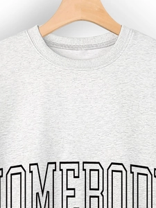 Close-up of heather grey crewneck sweatshirt featuring black SOMEBODY varsity print