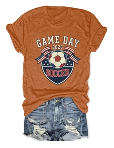 Mise à plat d'un T-shirt orange Game Day 2026 Soccer et d'un short en jean usé