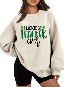 Detailed view of Luckiest Teacher Ever print with green clovers on a cream sweatshirt