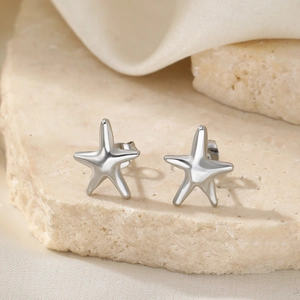 Boucles d'oreilles étoiles de mer en argent poli sur un support en pierre