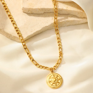 Dettaglio catena Figaro placcata oro 18K con medaglione sole su sfondo di seta