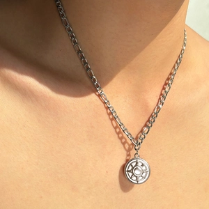 Dettaglio collana a catena Figaro argento con ciondolo rotondo inciso a stella