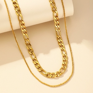 Gros plan sur le collier Figaro double couche plaqué or avec détails texturés