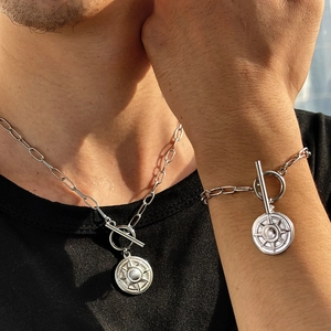 Detail view of silver paperclip chain necklace and bracelet set with star pendant