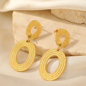 Macro detail of 18K gold plated stainless steel earrings with woven twisted texture