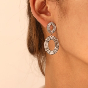 Close-up of silver-toned double hoop earrings with a vintage twisted spiral texture