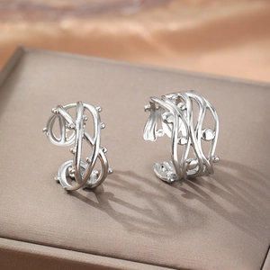 Artistic thorn-style hollow C-shaped earrings with metallic bead accents on silk
