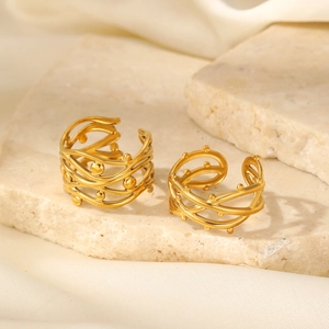Detail of two gold-plated thorn branch rings with bead accents on natural stone