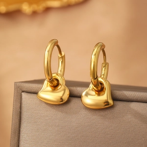 Boucles d'oreilles créoles coeur doré poli présentées sur un coffret cadeau de luxe