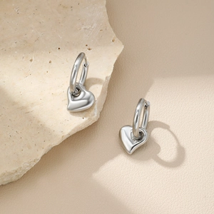 Boucles d'oreilles cœur argentées polies avec créoles sur fond de pierre naturelle