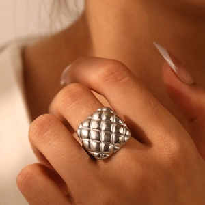 Macro view of silver quilted geometric ring featuring luxury square lava texture