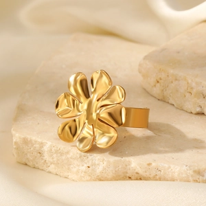 Macro di un anello a fiore in oro lucido su base in pietra con ombreggiature tenui