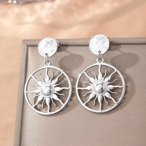 Boucles d'oreilles soleil argentées polies avec clous martelés sur boîte à bijoux