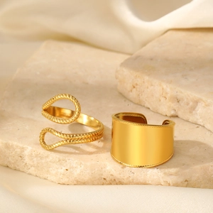 Detail view of two gold-plated rings with twisted texture and beaded edge on stone