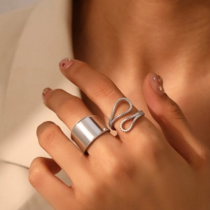 Detail of wide smooth silver band with beaded edges and textured wave open ring set