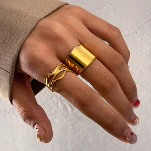 Detail of 18k gold double-layered textured open ring set worn by model in beige suit