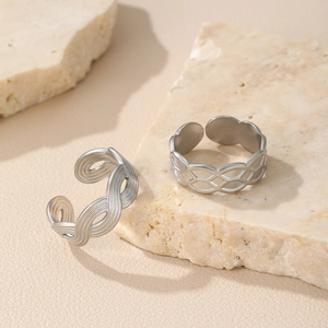 Detail of vintage silver braided and geometric lattice adjustable open rings on marble