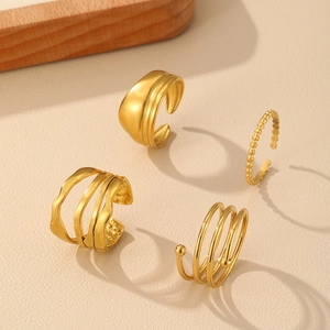 Set of four gold stainless steel rings with textured matte and spiral adjustable designs