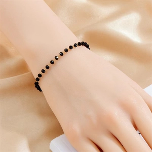 Bracelet de cheville mode avec perles noires et chaîne dorée sur fond de soie