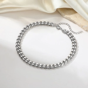 Polished stainless steel Cuban chain anklet with lobster clasp on an elegant background