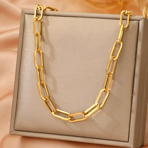 Elegante collana a maglie dorate a graffetta su una scatola di gioielli con seta